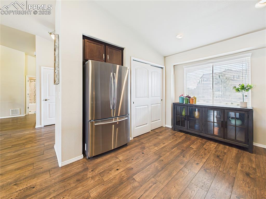 Image 15 of 50: Bright eat-in area off the kitchen with large windows and ample space for a