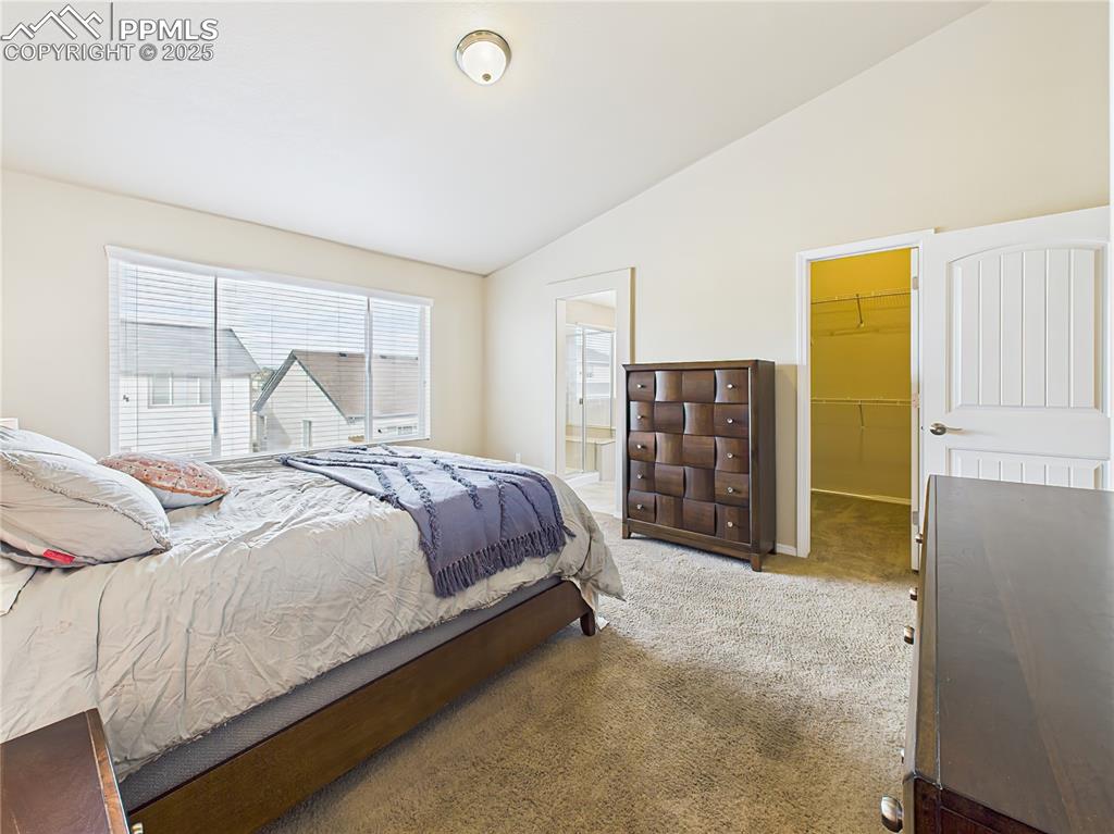Image 18 of 50: Spacious primary suite with vaulted ceilings, plush carpeting, and a large 