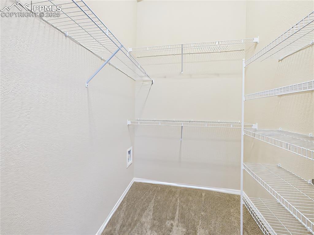 Image 19 of 50: Spacious walk-in closet with built-in shelving and ample storage for organi