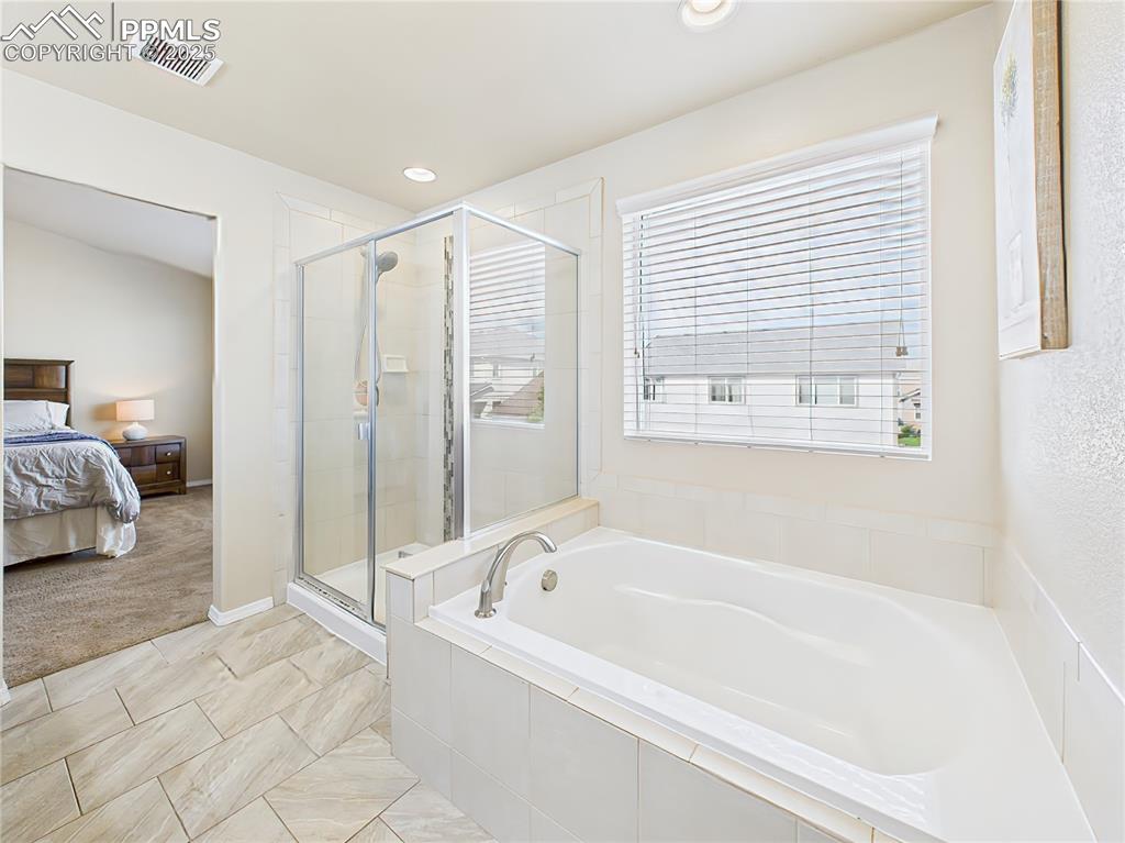Image 21 of 50: Soaking tub and glass-enclosed shower create a spa-like retreat.