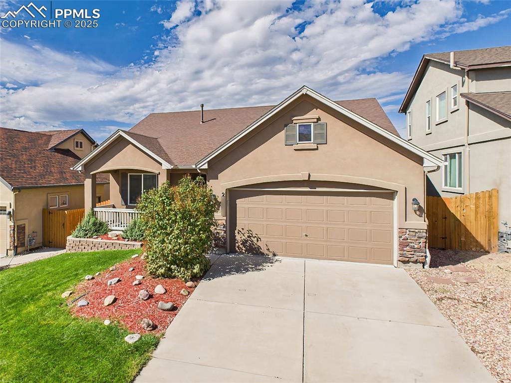 Image 39 of 50: Attractive stucco and stone exterior with two-car garage.