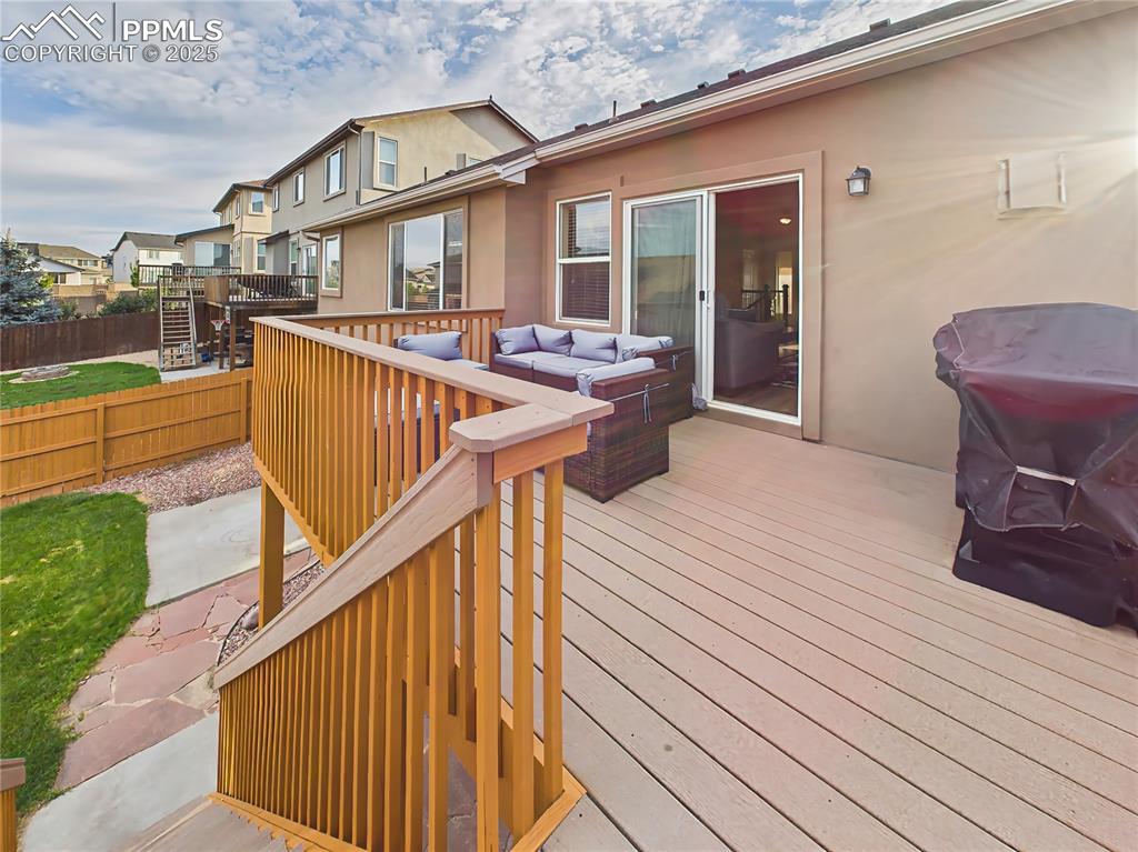 Image 41 of 50: Convenient stair access connects the deck to the backyard patio and lawn.