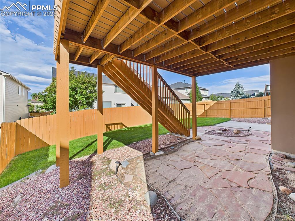Image 47 of 50: Lower Patio – Covered flagstone patio offers a shady retreat and overlooks 