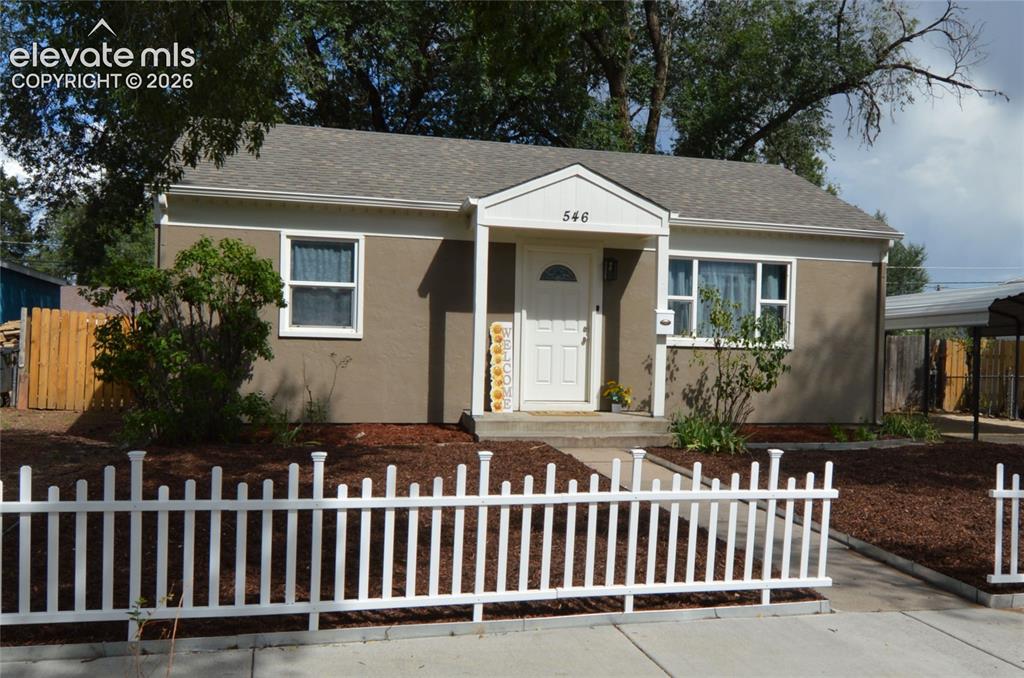Caption: A fully xeriscaped front yard with a white picket fence!