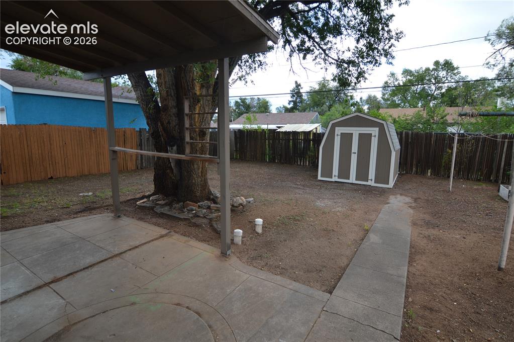 Image 20 of 23: The covered patio with the shed in the back.