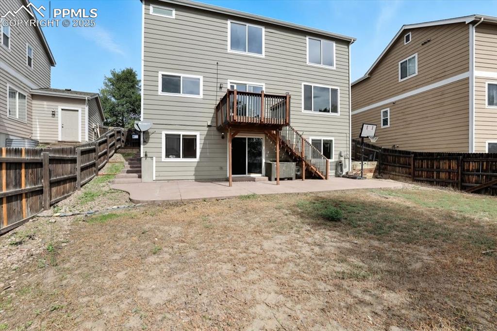 Image 34 of 44: Backyard with raised deck and stamped patio.