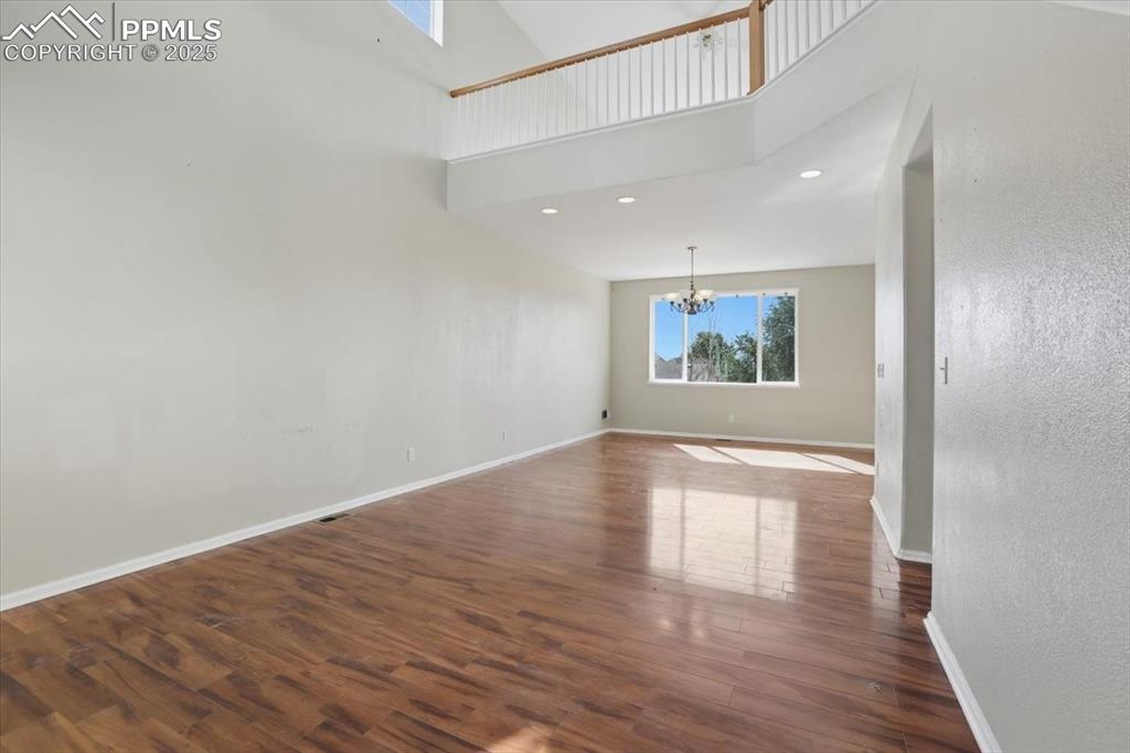 Image 5 of 44: Living room and dining area with balcony above.