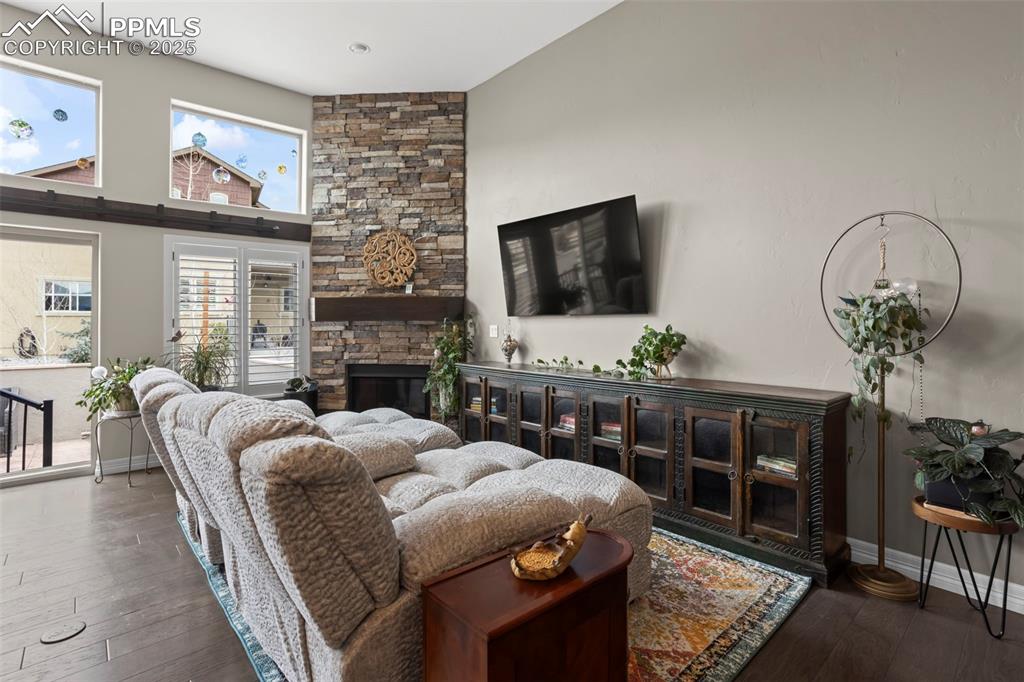 Image 11 of 47: Living room featuring a fireplace, baseboards, and hardwood / wood-style fl