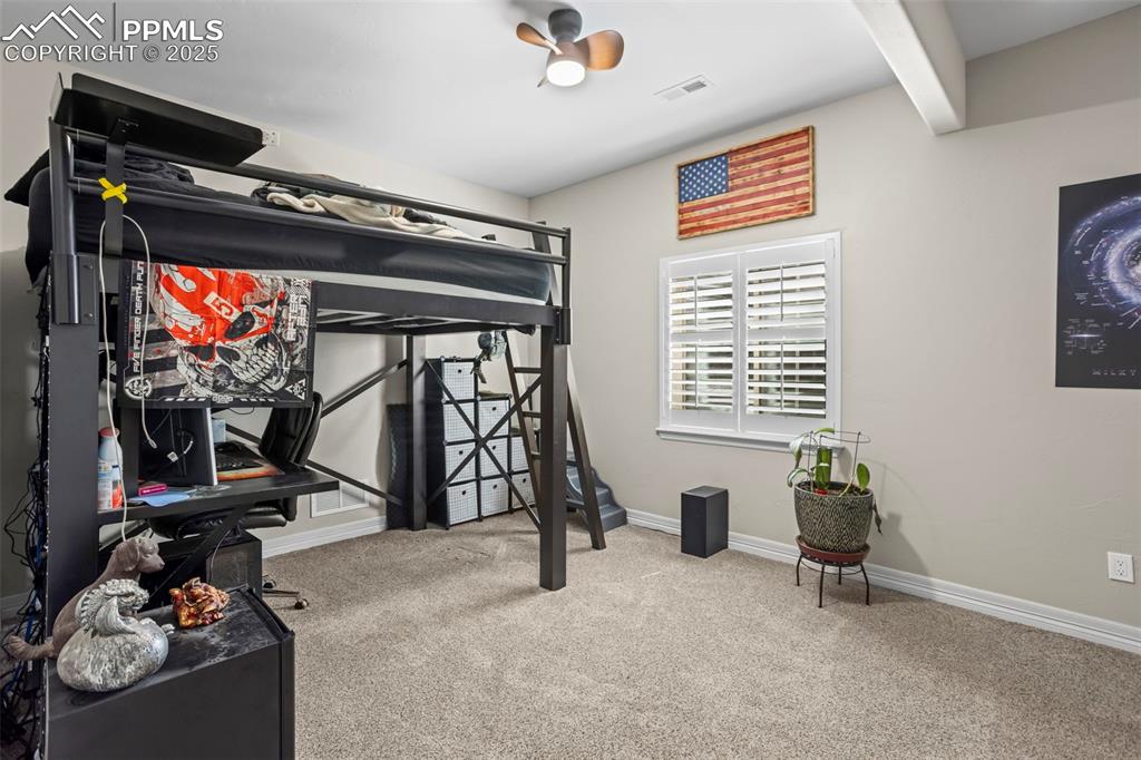 Image 34 of 47: Carpeted bedroom featuring beamed ceiling, baseboards, and visible vents