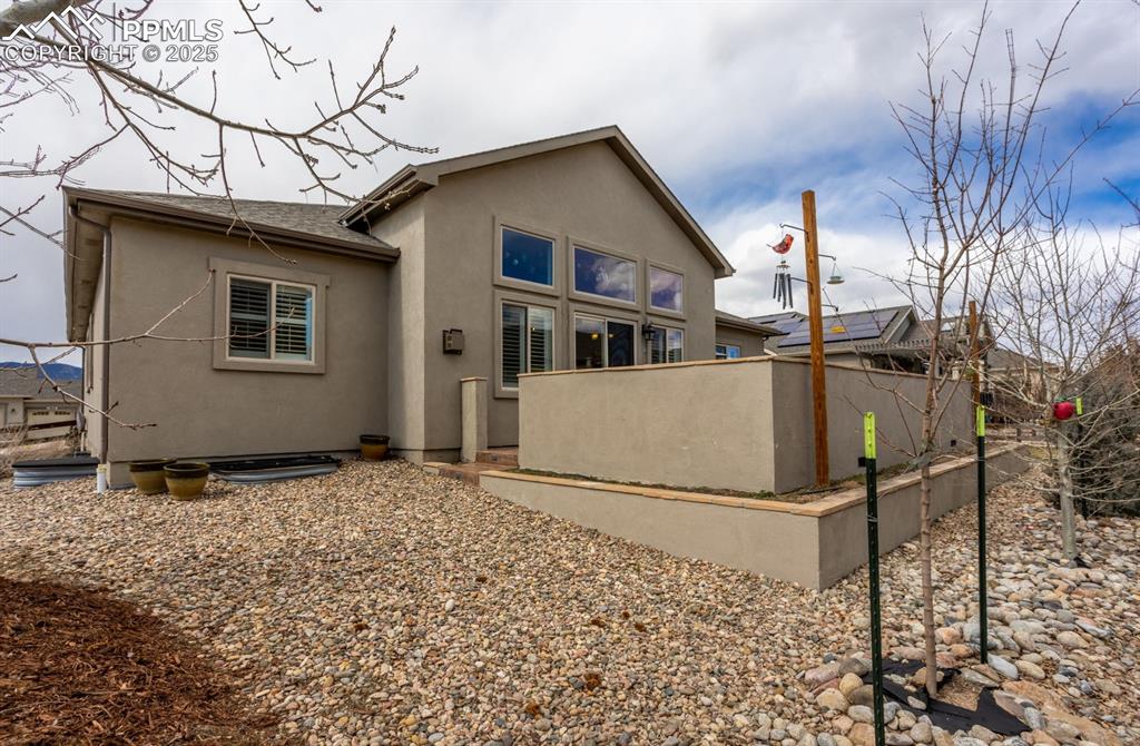 Image 39 of 47: Back of property with stucco siding, roof with shingles, and fence