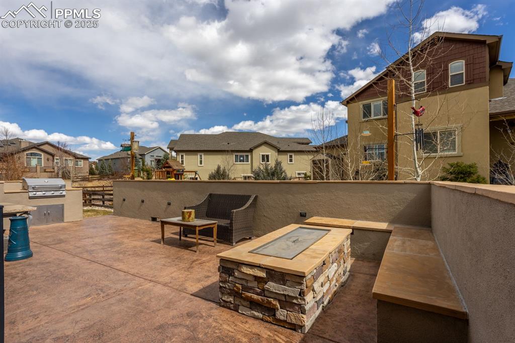Image 42 of 47: View of patio / terrace with area for grilling, a residential view, a fire