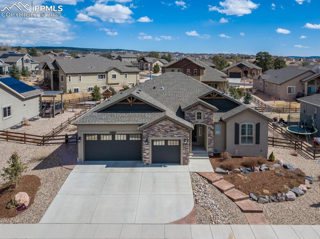 Image 44 of 47: View of front facade with fence, roof with shingles, an attached garage, co