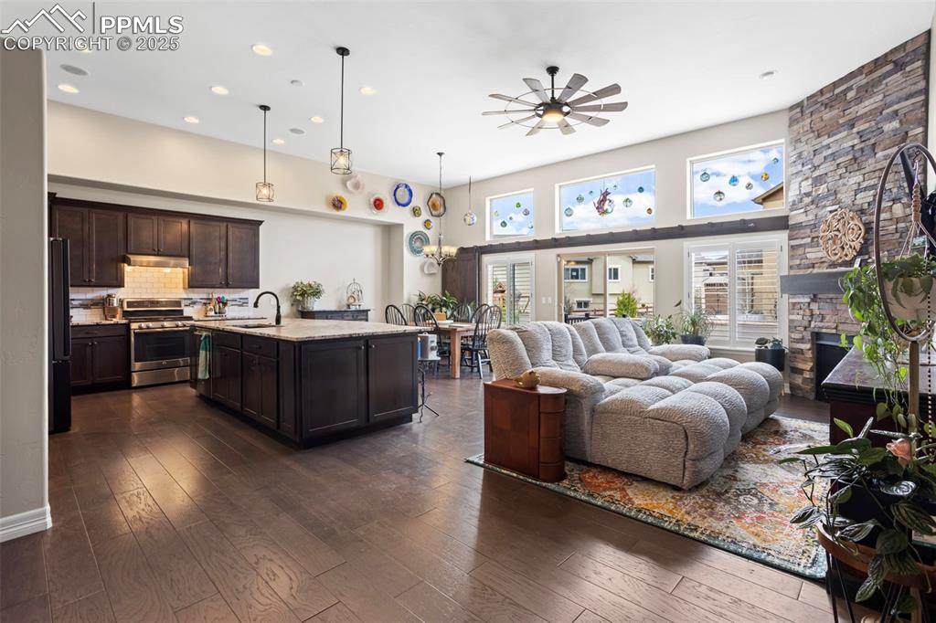 Image 6 of 47: Living room featuring a ceiling fan, recessed lighting, a fireplace, a towe