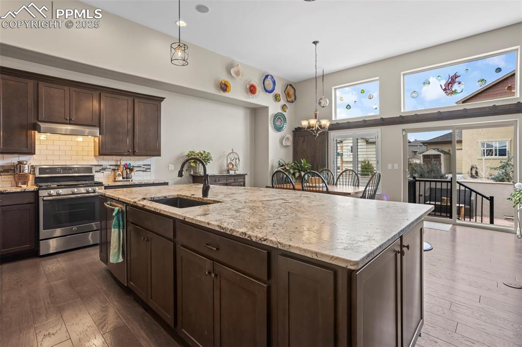 Image 7 of 47: Kitchen featuring a sink, dark wood finished floors, under cabinet range ho