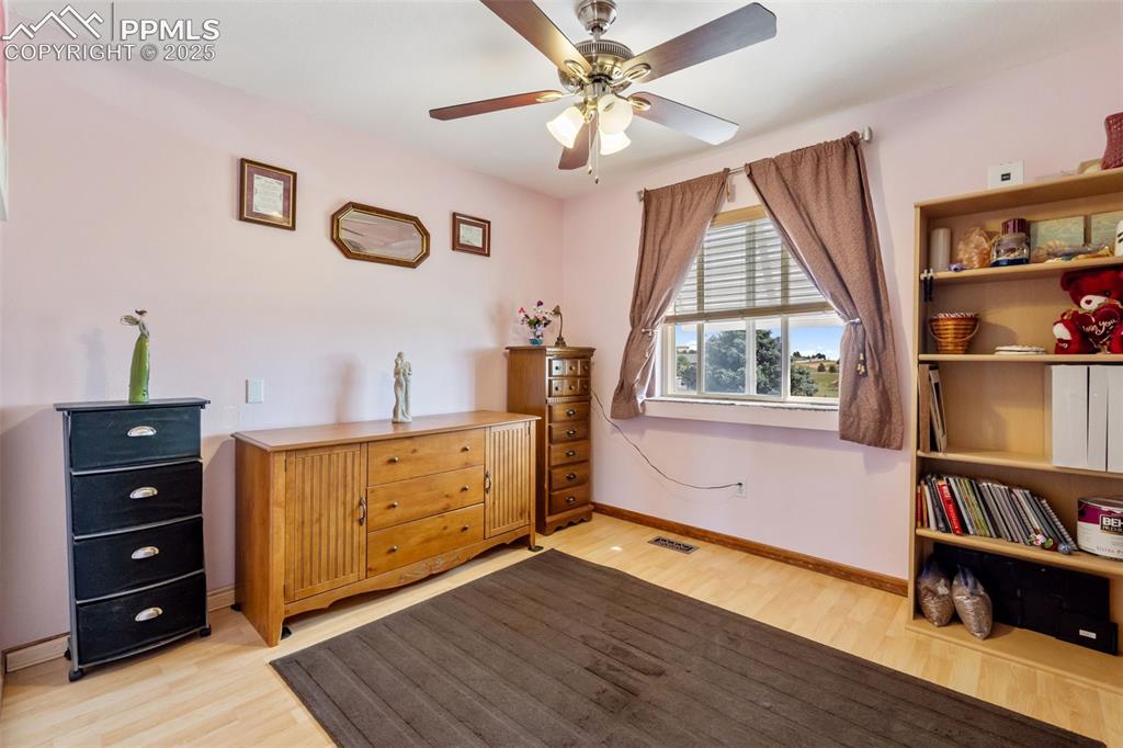Image 14 of 38: Secondary upper level bedroom with natural light and wood floors
