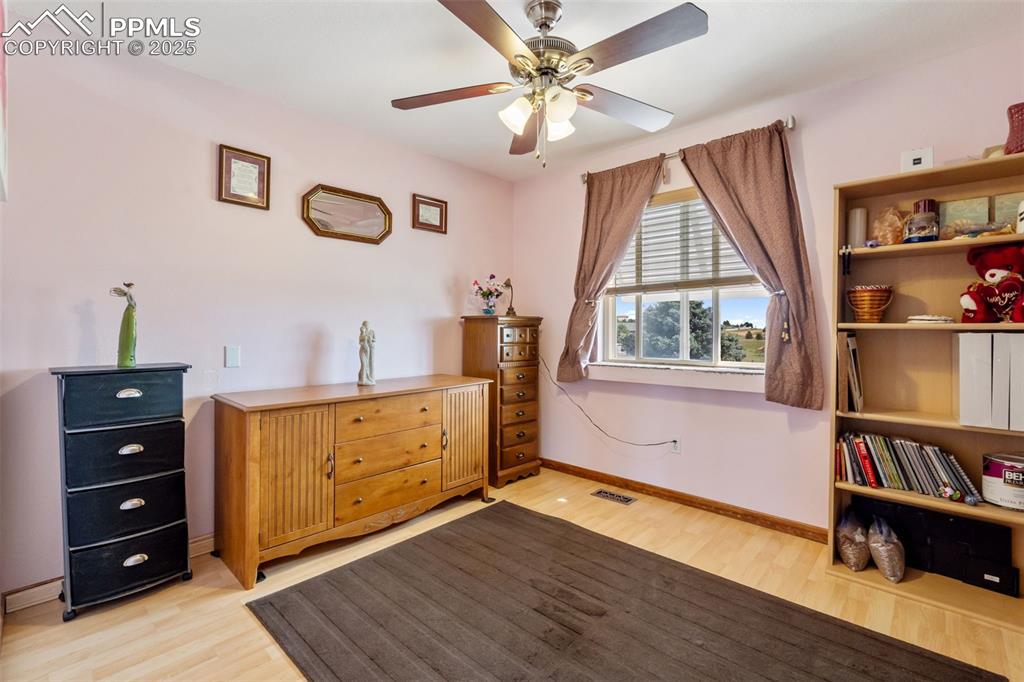 Image 15 of 38: Secondary upper level bedroom with natural light and wood floors