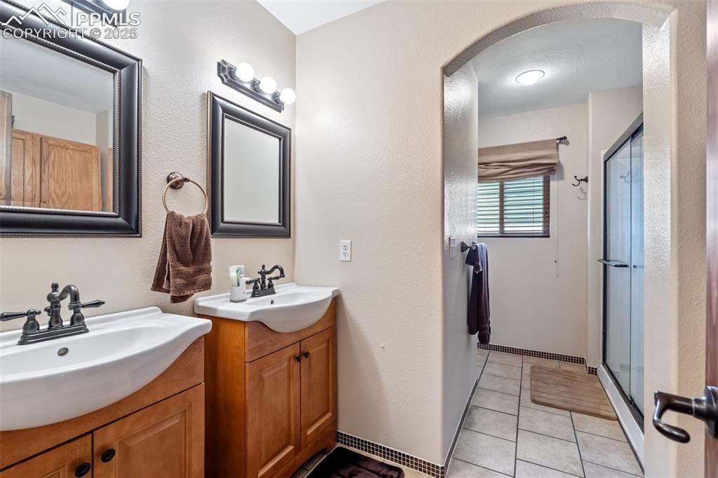 Image 17 of 38: Updated full bathroom with modern vanity and lighting