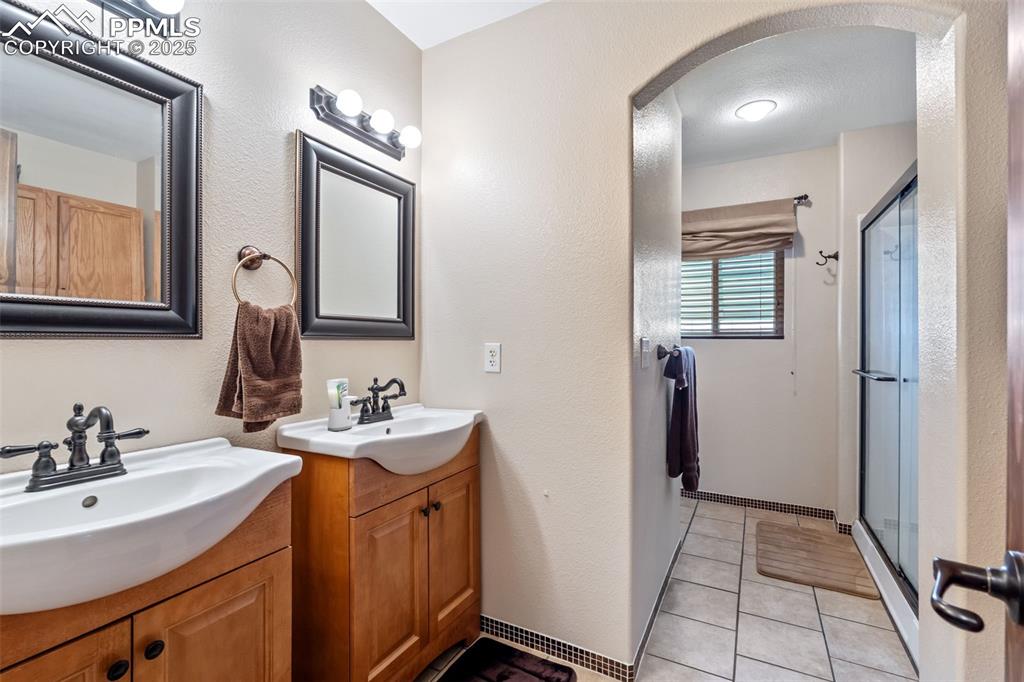 Image 18 of 38: Updated full bathroom with modern vanity and lighting