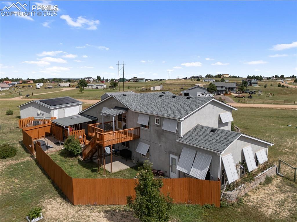 Image 2 of 38: Backyard aerial with deck, fencing, and open space