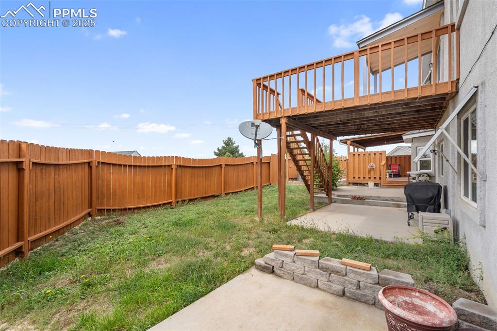Image 32 of 38: Fenced backyard with patio space