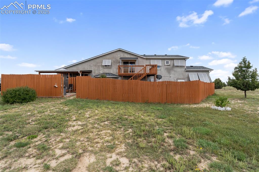 Image 34 of 38: Rear exterior with deck and fencing