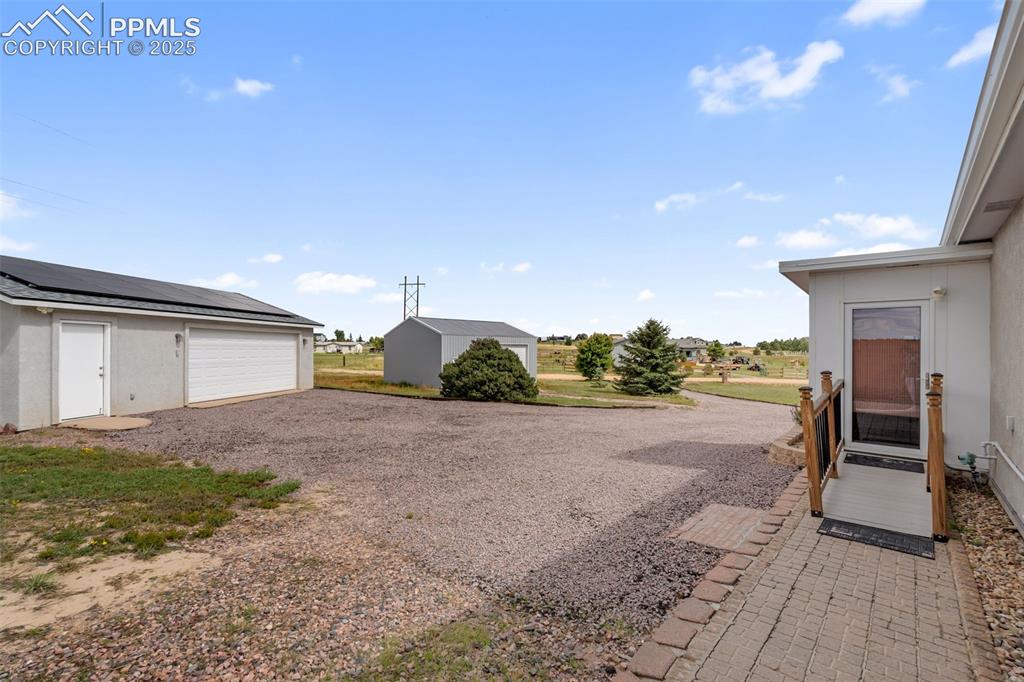 Image 35 of 38: Detached 2-car garage with solar and extra workshop space.