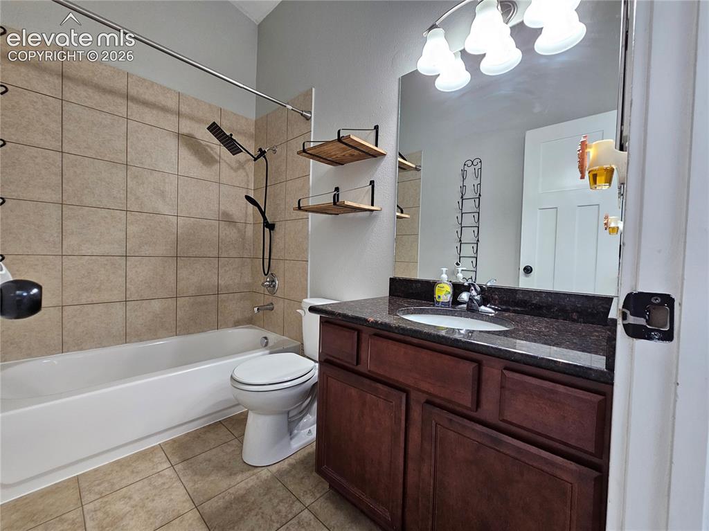 Image 11 of 15: Full bathroom featuring a dark wood-finish vanity with a dark granite-style