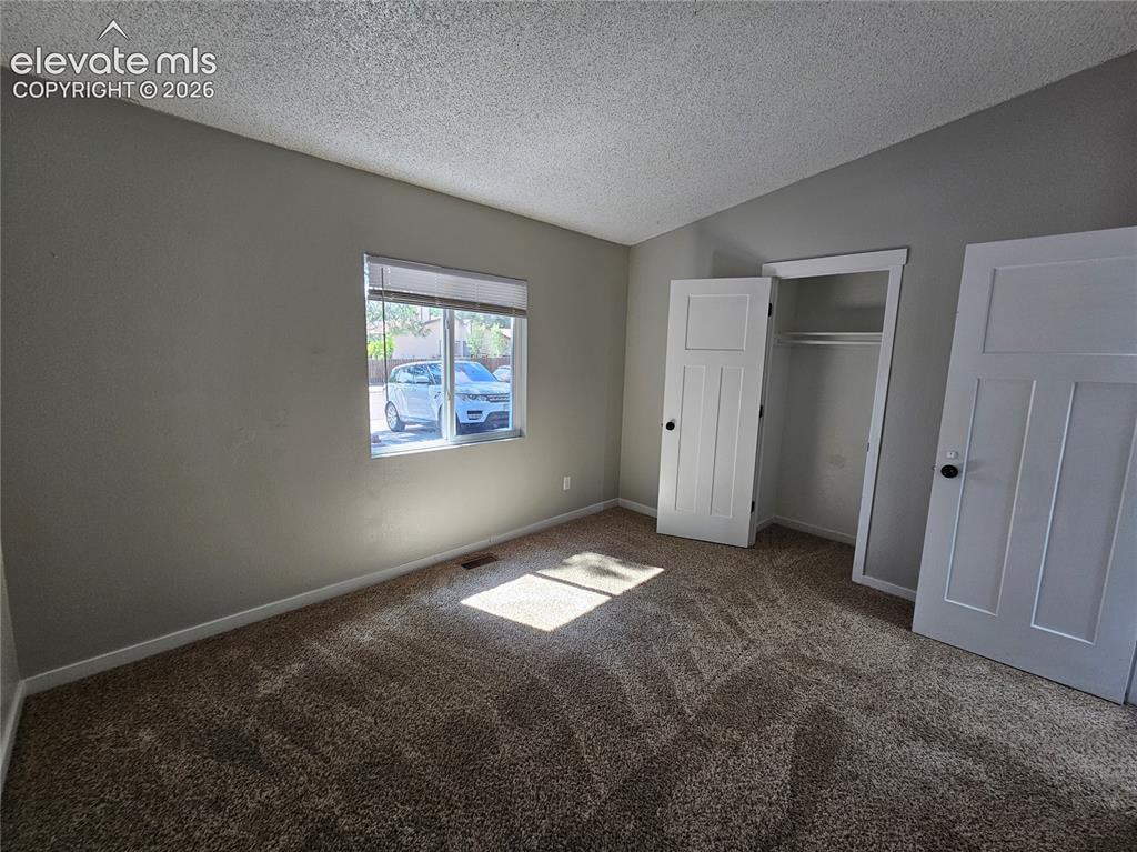Image 13 of 15: Carpeted room featuring a window with blinds, baseboard trim, two white pan