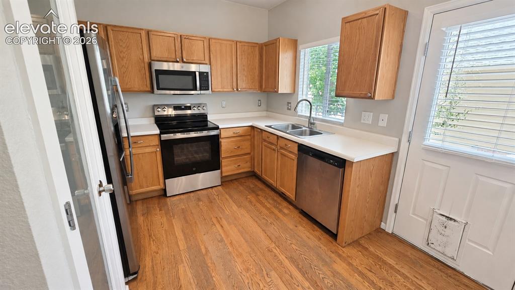 Image 10 of 27: Kitchen featuring wood-finish flooring, light wood cabinetry, stainless ste