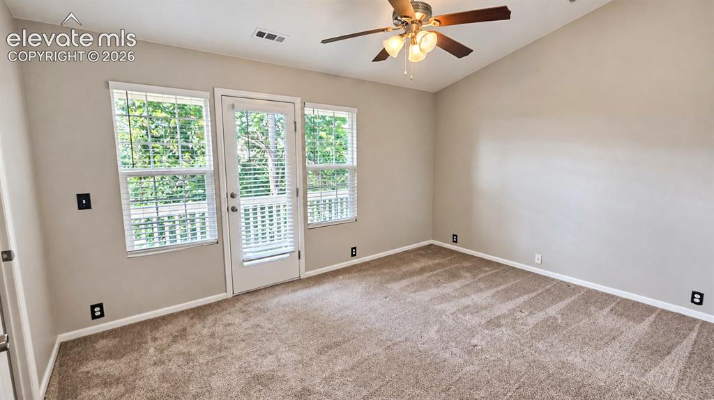 Image 16 of 27: Vaulted ceiling, ceiling fan with integrated lighting, door with integrated