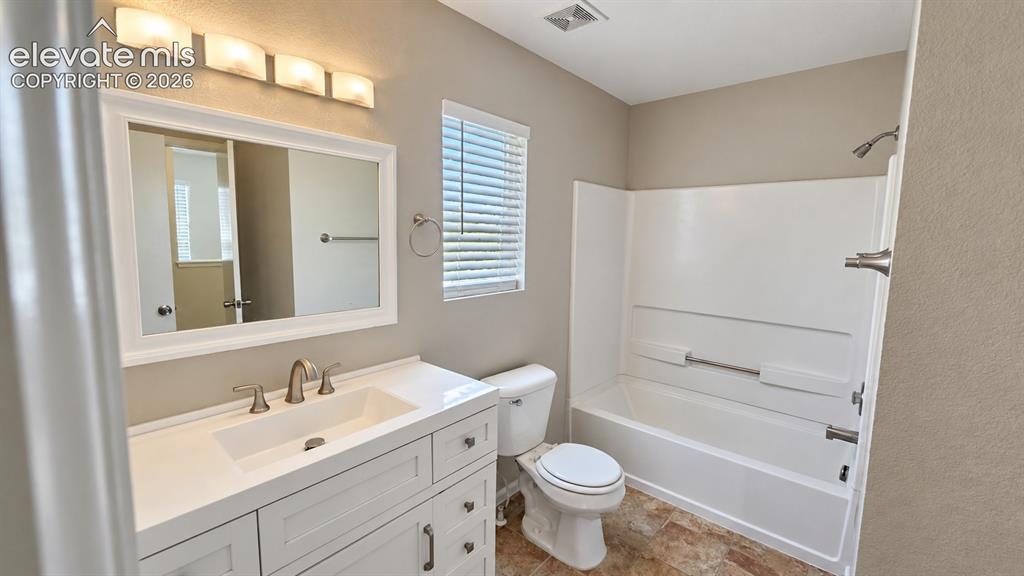 Image 17 of 27: White vanity with integrated sink, brushed nickel fixtures, wall-mounted mi