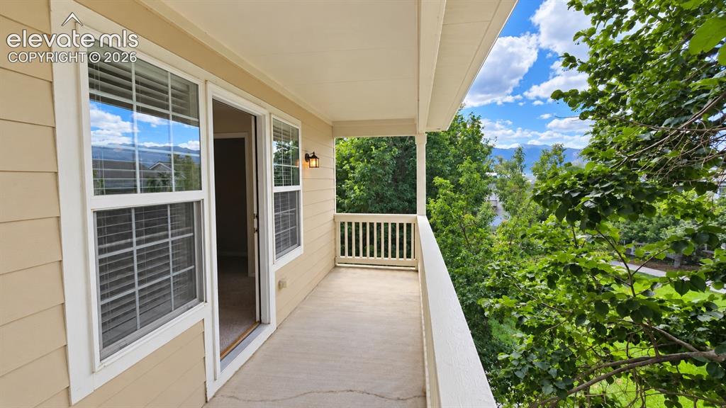 Image 18 of 27: Covered balcony featuring siding exterior, white railing, and wall-mounted