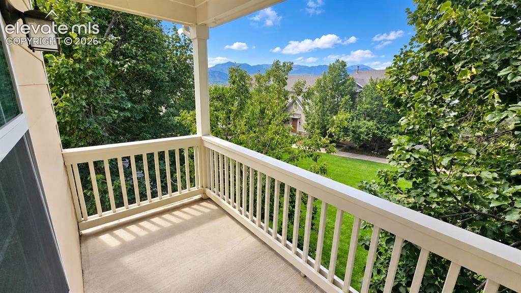 Image 19 of 27: Covered balcony featuring white railings and a concrete surface