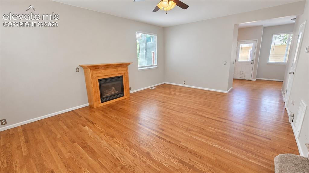 Image 5 of 27: Hardwood flooring throughout, recessed fireplace with wood mantel, ceiling 