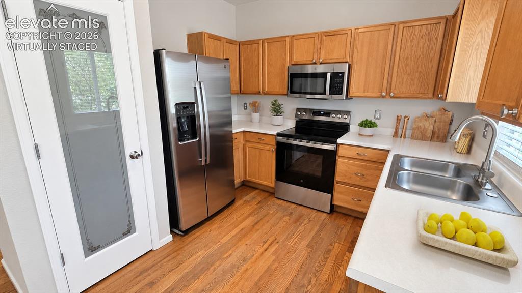 Image 8 of 27: Wood-finish flooring, stainless steel appliances, light wood cabinetry, dua