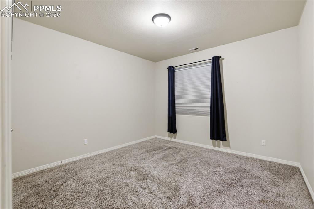 Image 21 of 39: Carpeted spare room with baseboards and a textured ceiling