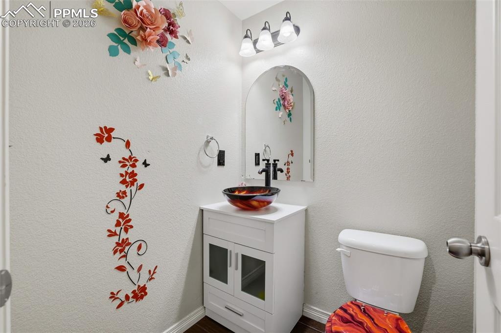 Image 23 of 39: Half bath with vanity and a textured wall