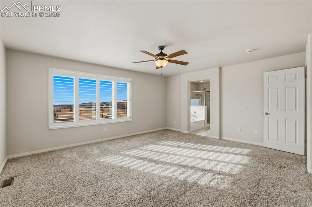 Image 28 of 39: Unfurnished bedroom with ceiling fan, carpet, and ensuite bathroom