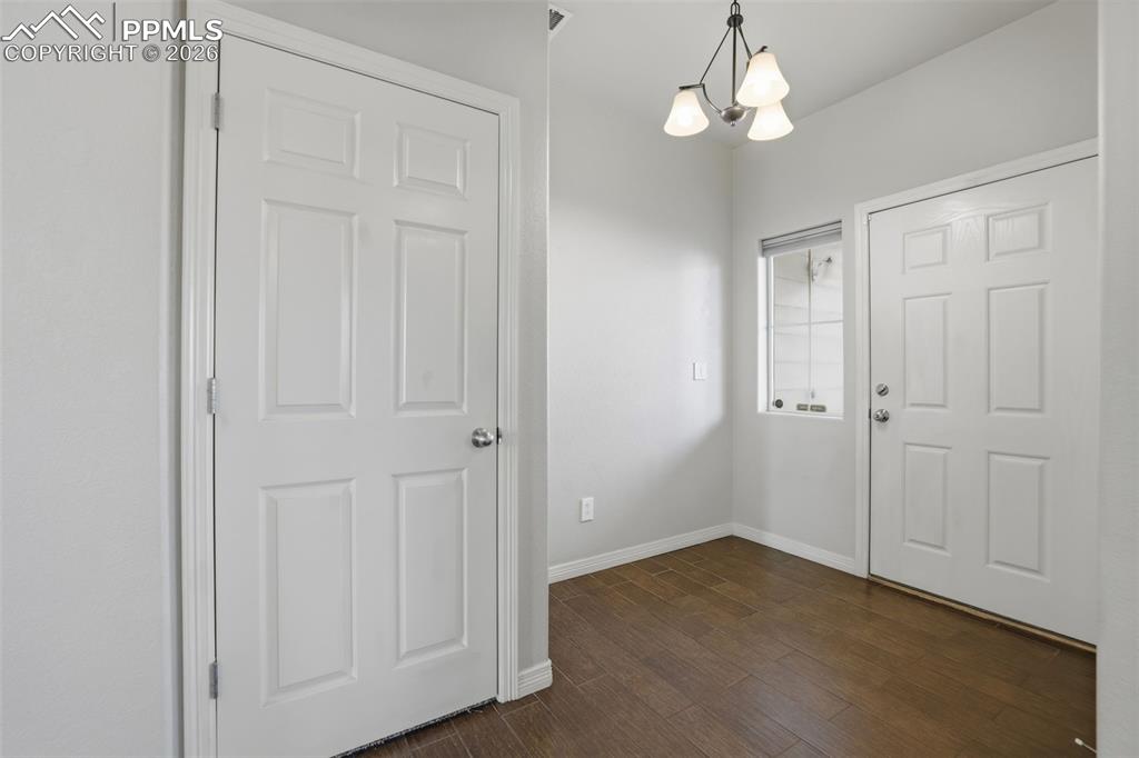 Image 5 of 39: Foyer with a chandelier and dark wood-style floors