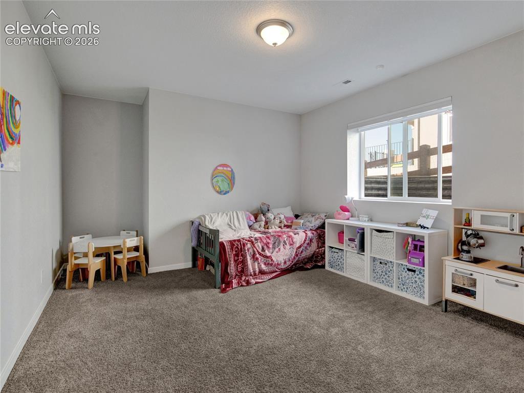 Image 13 of 17: Spacious room featuring neutral carpeting, light gray wall paint, and a whi