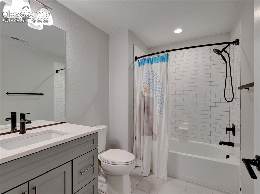 Image 14 of 17: Bathroom featuring a gray vanity with an integrated sink, white countertop,