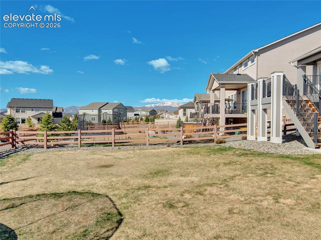 Image 17 of 17: Rear exterior of the property featuring a light-colored stucco finish and a
