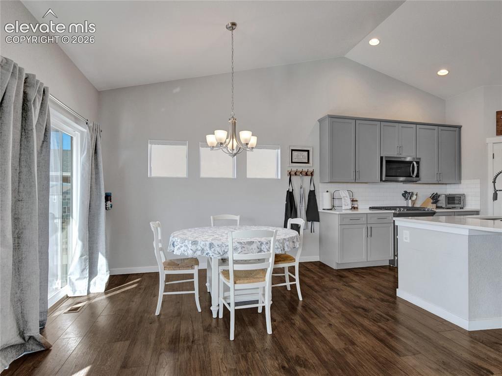 Image 4 of 17: Open-concept kitchen and dining area featuring wood-finish flooring, vaulte