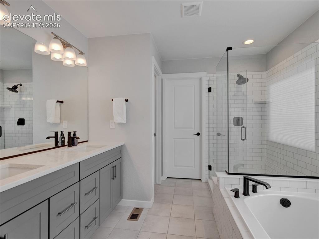 Image 8 of 17: Bathroom featuring a dual vanity with grey cabinetry and white countertops,