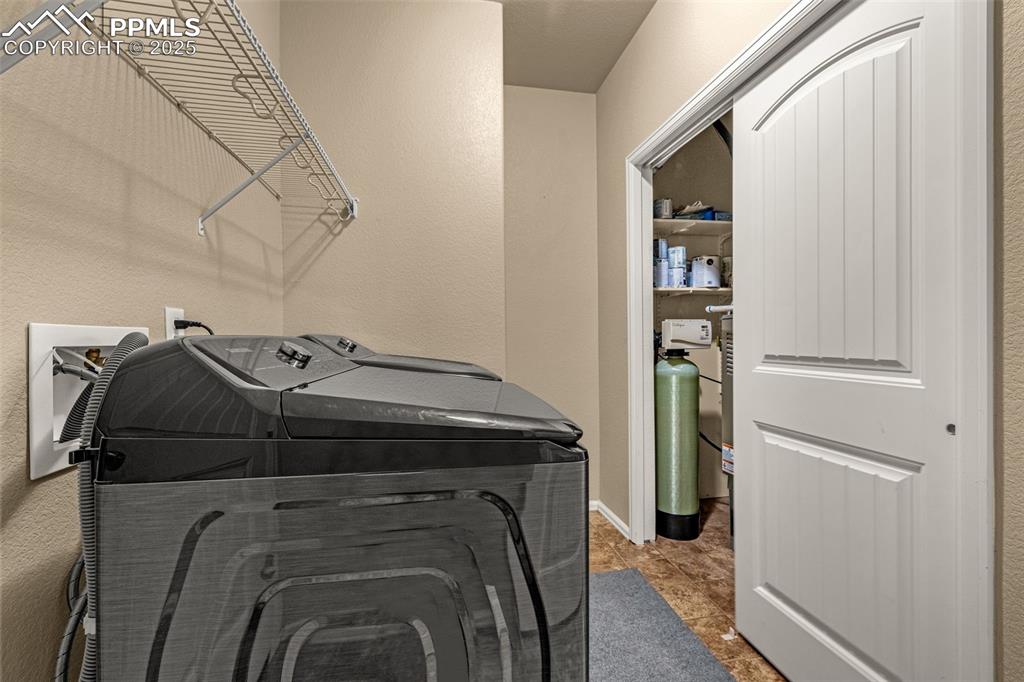 Image 13 of 28: Owner entry with washer, dryer, whole house water system and HVAC system.  