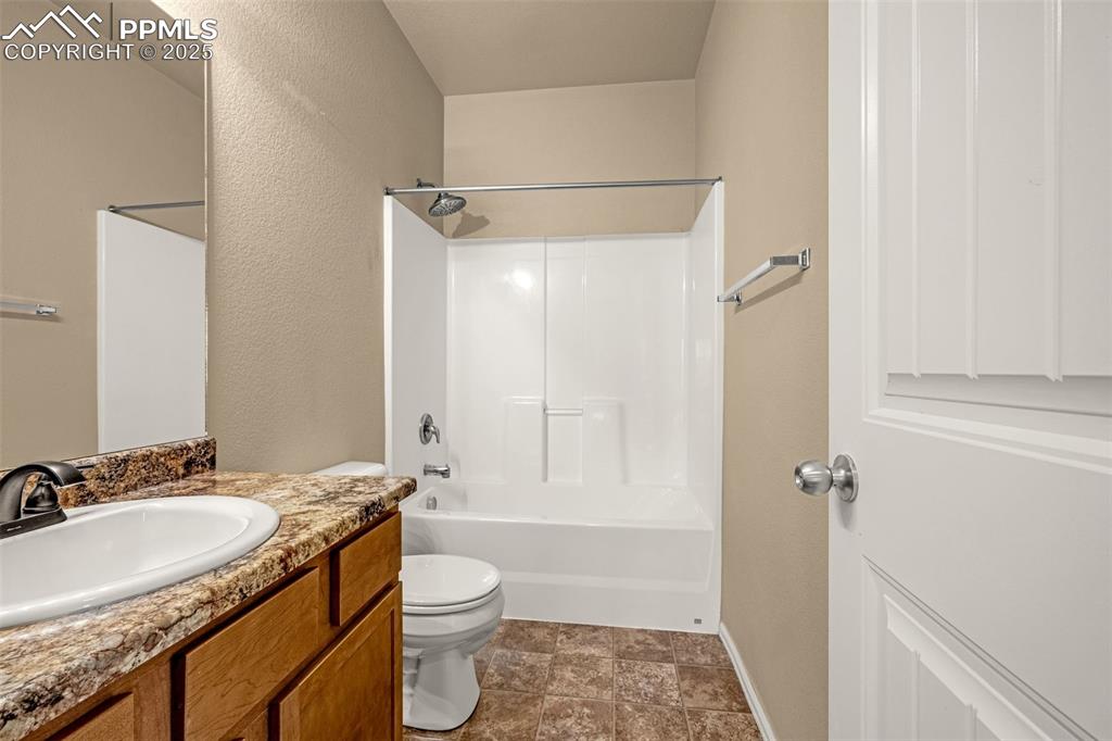 Image 20 of 28: Shared full bathroom with smooth counters, shaker style cabinets and shower