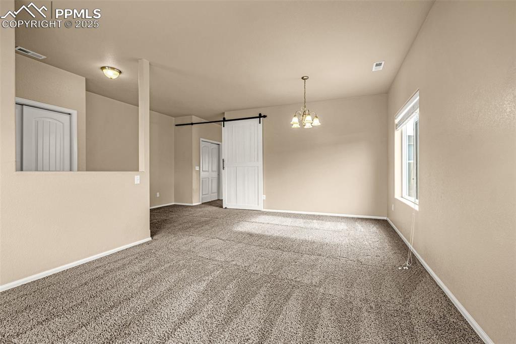 Image 5 of 28: Another view of the Living room with barn door to separate the space.