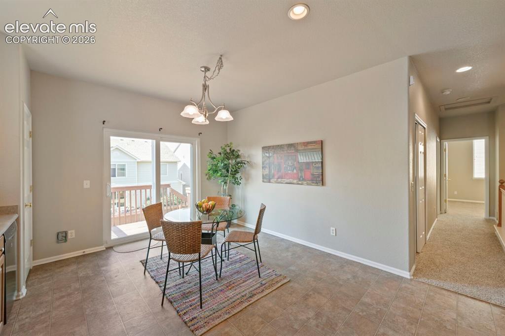 Image 10 of 45: Eat-in kitchen featuring wood-finish cabinetry, black appliances, recessed 