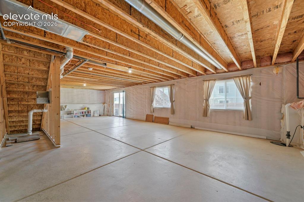 Image 15 of 45: Expansive unfinished basement featuring a concrete floor and exposed wood c
