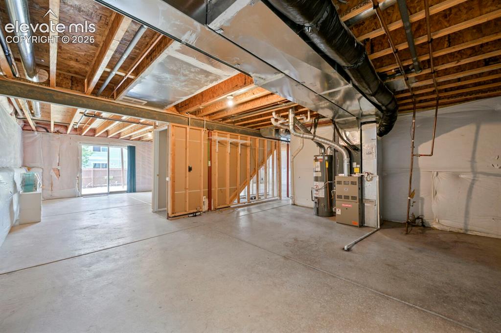 Image 17 of 45: Unfinished basement with exposed ceiling joists and concrete flooring, clot